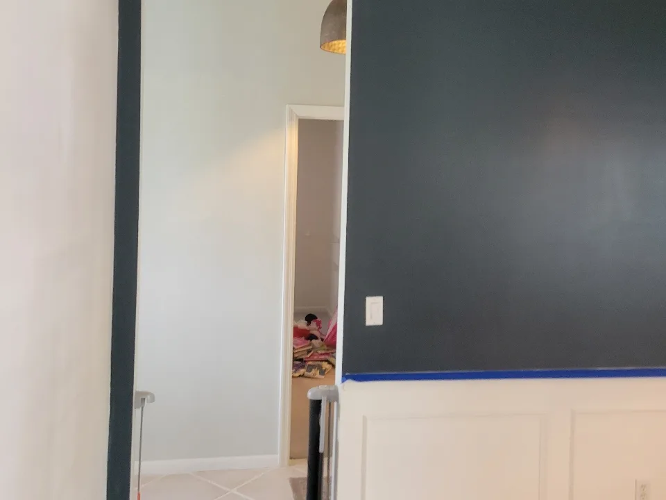 Dated charcoal blue-gray accent wall above white wainscoting before repainting