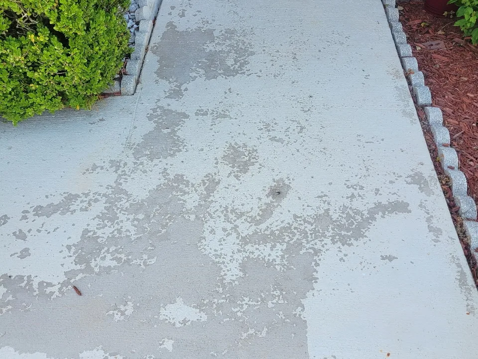 Discolored, stained gray concrete front walkway before coating
