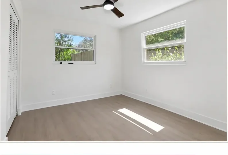 The same bedroom finished in clean, bright white with refreshed trim and flooring