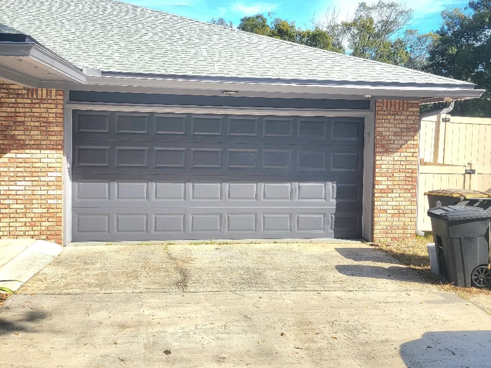 The same garage door finished in durable charcoal gray