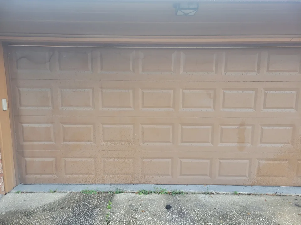 Faded, stained tan garage door before repainting