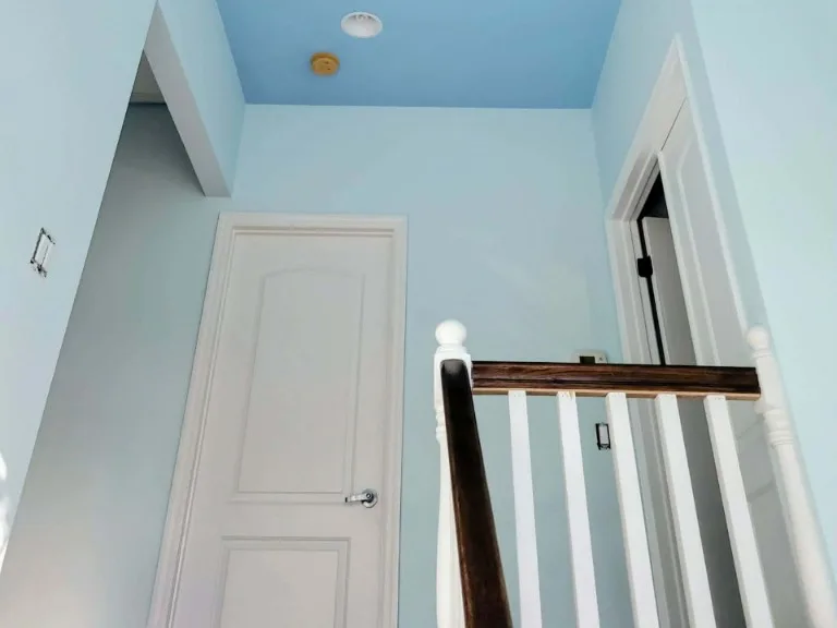 The same stairwell ceiling and walls finished in soft sky blue